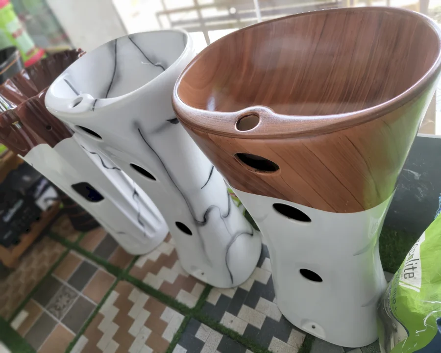 Stack of white and wood-finish designer wash basins at Shri Tiles